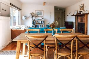 uma sala de estar com uma mesa de madeira e cadeiras em Bay of Fires - Beachfront - Sloop Cottage em Binalong Bay