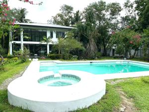 a swimming pool in front of a house at G-Hotel Luxury Villa Resort & Hot Spring in Anos