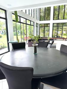 a dining room with a table and chairs and windows at G-Hotel Luxury Villa Resort & Hot Spring in Anos