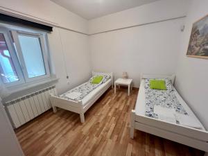 ユジェフフにあるSosnowy apartamentのベッド2台と窓が備わる客室です。