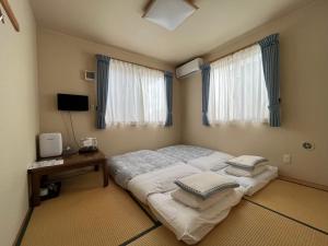 a bedroom with a large bed with pillows on it at Karin doo Hotel in Narita