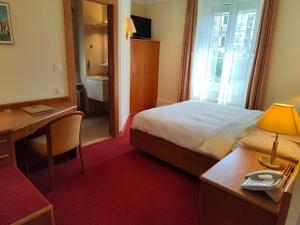 a hotel room with a bed and a desk and a desk at Elite in Lausanne