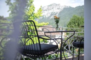 a table with a vase of flowers on a balcony at Villa Rein Boutiquehotel in Bad Reichenhall
