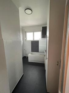 a bathroom with a tub and a toilet and a window at Appartement F3 Cocooning in Montigny-lès-Metz