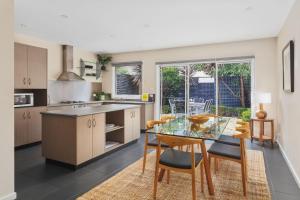 a kitchen with a glass table and some chairs at Boutique Stays - Roxys Place in Melbourne