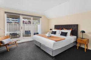 a bedroom with a large bed and a balcony at Boutique Stays - Roxys Place in Melbourne