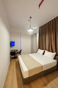 a bedroom with a bed and a desk in it at ApartHotel Folé in Tirana