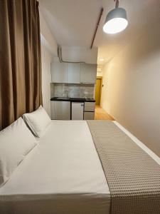 a bedroom with a large white bed in a room at ApartHotel Folé in Tirana