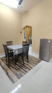 Un comedor con una mesa y dos sillas. en D'PAYA HOMESTAY, en Bachok