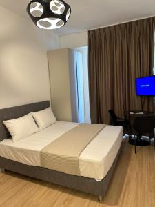 1 dormitorio con cama, mesa y TV en ApartHotel Folé en Tirana