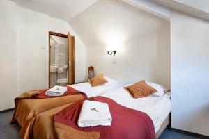 a bedroom with two beds with towels on them at FAMILIJNY Ośrodek Wypoczynkowo - Rehabilitacyjny Krynica Zdrój in Krynica Zdrój