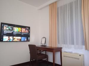 a room with a desk and a tv on the wall at Apartments Kuce Lekovica Beach & snack bar- Bistro in Bar