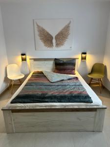 ein Schlafzimmer mit einem großen Bett mit 2 Stühlen in der Unterkunft Villa GECKO in Medulin
