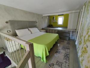 una camera con un letto e una coperta verde di Mini Loft Fronte Mare a Pescara