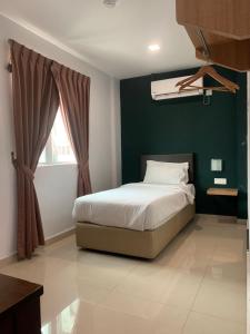 a bedroom with a bed and a green wall at Room V by SECOM Jalan Megat in Batu Pahat