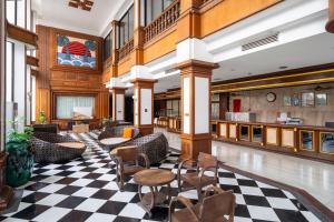 un vestíbulo con suelo a cuadros y sillas en Welcome Plaza Hotel Pattaya, en Pattaya central