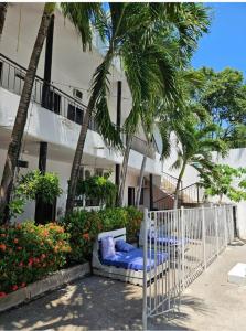 a bed in front of a building with palm trees at Hotel Zulan in Tolú