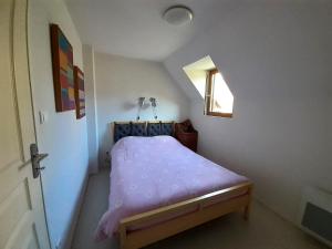 a small bed in a small room with a window at Joli triplex 3 étoiles, avec jardin et cheminée in Génos