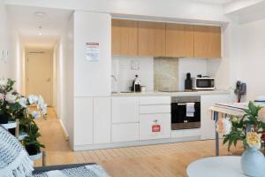 a kitchen with white appliances and wooden cabinets at Little escape at Balfours 1BR Wifi Spa Swim in Adelaide
