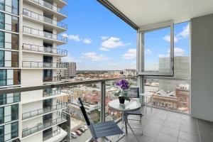 a balcony with a table and chairs and a view of a city at Little escape at Balfours 1BR Wifi Spa Swim in Adelaide