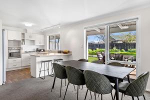 uma cozinha e sala de jantar com mesa e cadeiras em It's Easy! Space and comfort em Wanaka