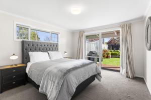 a bedroom with a bed and a large window at It's Easy! Space and comfort in Wanaka