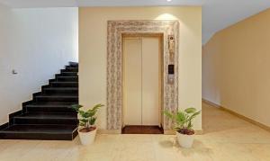 a hallway with stairs and potted plants at Treebo Trend Heaven Grand in Lucknow