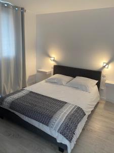 een slaapkamer met een groot bed met 2 lampen bij Appartement avec jacuzzi in Porto-Vecchio