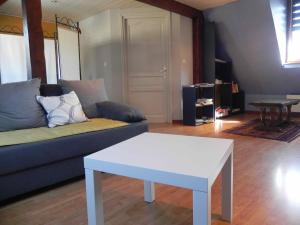 a living room with a blue couch and a white table at Gite Des Trois in Orschwiller