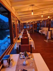 ein Restaurant mit weißen Tischen, Stühlen und Fenstern in der Unterkunft agva temmuz otel in Sile