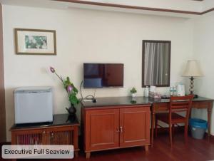 uma sala de estar com uma secretária com uma televisão e uma secretária em Alpine LXPD Full Seaview Water Chalet em Porto Dickson