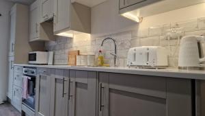 cocina con armarios blancos y encimera en Luxury Cardiff Apartment with Free parking, Free high-speed internet, Fully Equipped Kitchen, en Cardiff