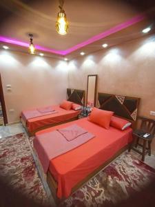 dwa łóżka w pokoju z czerwoną pościelą w obiekcie جناح فندقي أمام جامعة المنصورة w mieście Al-Mansura