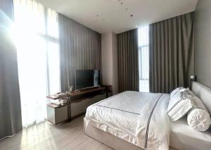 a bedroom with a white bed and a television at NEW Charming 2BR Apartment in Central Jakarta in Jakarta