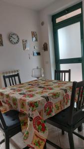 una mesa de comedor con un mantel de flores. en Casa Vacanze Lanuvio Stazione, en Lanuvio