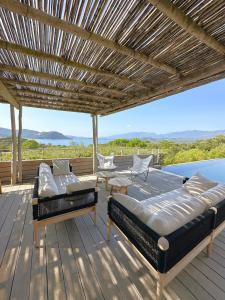terraza de madera con 2 camas y pérgola en Villa Cala Rossa en Lecci