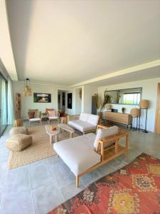 una gran sala de estar con sofás y una alfombra en Villa Cala Rossa en Lecci