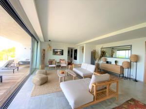 sala de estar con muebles blancos y espejo grande en Villa Cala Rossa, en Lecci