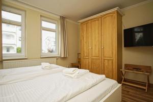 ein Schlafzimmer mit einem Bett mit zwei Handtüchern darauf in der Unterkunft mit Meerblick und Balkon, gratis Nutzung vom AHOI Erlebnisbad und Sauna in Sellin - Meeresblick FeWo 38 in Göhren + 21 Fotos