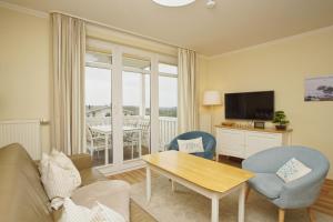 ein Wohnzimmer mit einer Couch und einem Tisch und Stühlen in der Unterkunft mit Meerblick und Balkon, gratis Nutzung vom AHOI Erlebnisbad und Sauna in Sellin - Meeresblick FeWo 38 in Göhren