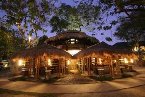 a large building with a thatch roof at night at Acuaverde Beach Resort in San Juan