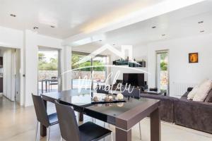 a dining room and living room with a table and chairs at Villa Colom in Son Carrio