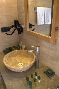 um lavatório numa casa de banho com um espelho e um lavatório em Ages in Cappadocia em Üçhisar