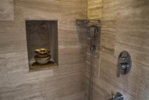 a shower with a glass door and a vase in a bathroom at Ages in Cappadocia in Uçhisar