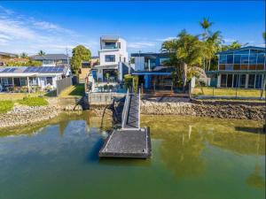 a bridge in a body of water with houses at Luxury Modern Waterfront House in Gold Coast