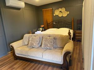 a living room with a couch in front of a bed at บ้านจันทร์ประดับ เขาใหญ่ in Pong Talong