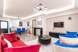 a living room with red and blue chairs and a television at Home away from home in Nairobi