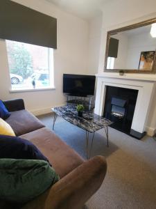 a living room with a couch and a table at Contractors Home Free Parking 5 MINS To City Centre in Hull