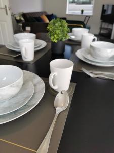 una mesa negra con platos blancos y una cuchara en Contractors Home Free Parking 5 MINS To City Centre, en Hull