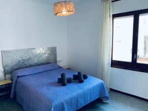 a bedroom with a blue bed with two teddy bears on it at Hauzify I Apartament Monlema in Sant Feliu de Guíxols